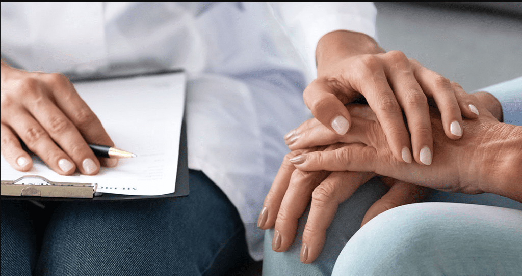 Doctor holding patient hands consoling